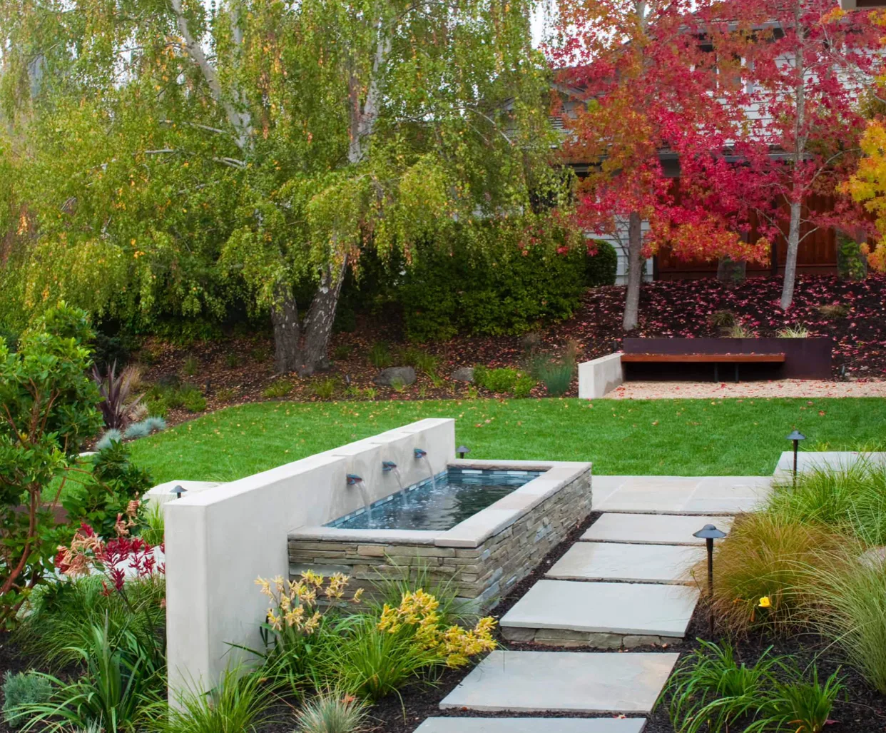 A garden of lawn, planting and water